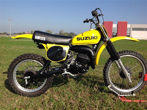 a suzuki dirt bike parked in the grass