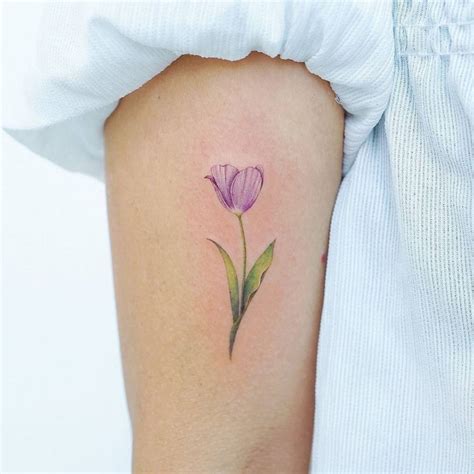 Watercolor tulip tattoo on the bicep.