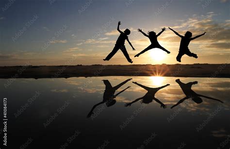 silhouette of kids jumping on beach in sunset Stock Photo | Adobe Stock