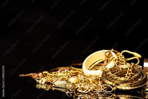 Bunch of gold jewelry against black background with copy space for text. Stock Photo | Adobe Stock