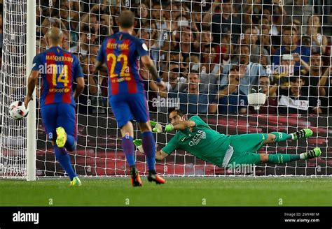 FC Barcelona's goalkeeper Claudio Bravo, right, saves a penalty during the Spanish Super Cup ...