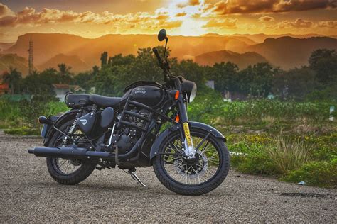 a black motorcycle parked on top of a dirt road