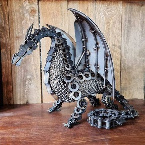 a metal dragon sculpture sitting on top of a wooden table