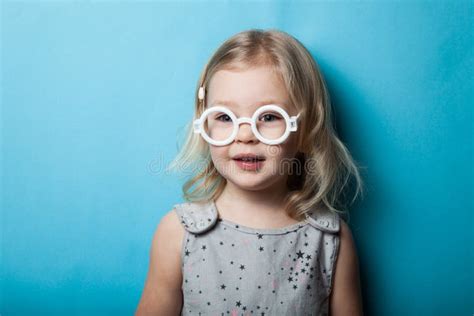 Interested Little Girl in Toy Glasses on a Blue Background Stock Image ...