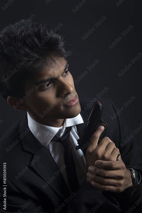 Secret agent posing on black background Stock Photo | Adobe Stock