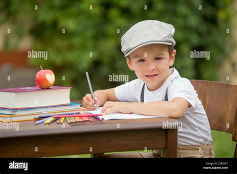 Boy, writing his homework from school, drawing and writing in his notebook, learning new things ...