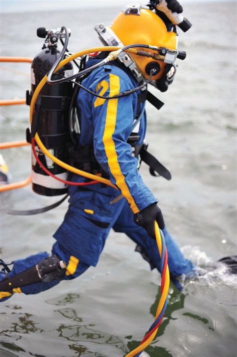 Diver jumping into the water wearing a Mark 12 outer garment | Scuba ...