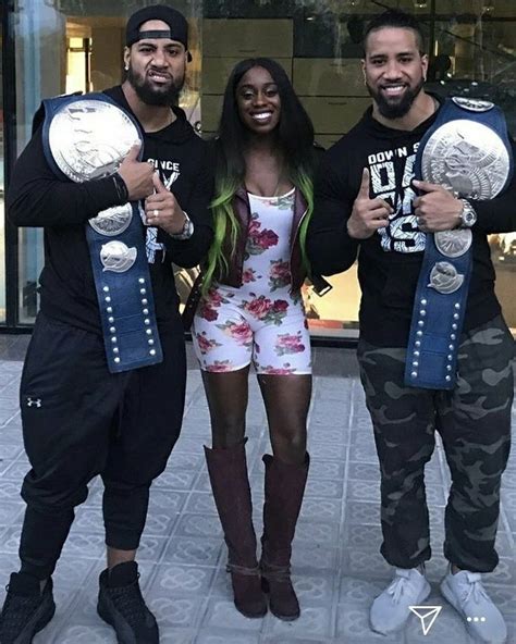 three people standing next to each other holding two silver and one black wrestling belts in ...