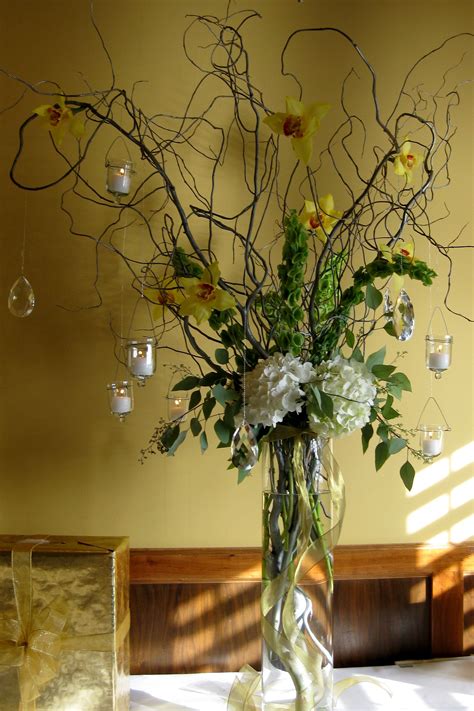 Tall and airy look with votives hanging off curly willow branches. Flowers included are ...