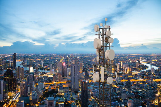 Telecommunication tower with 5G cellular network antenna on night city background