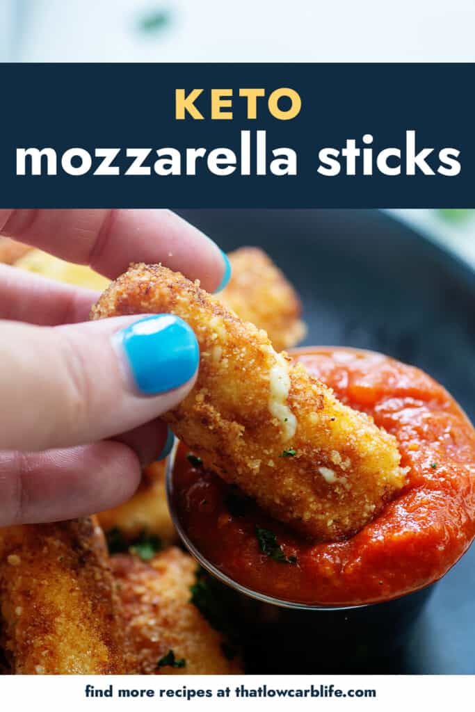 hand dipping a mozzarella stick in marinara.