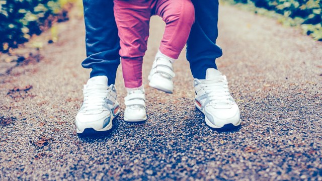 image of adult shoes and legs next to baby shoes and legs