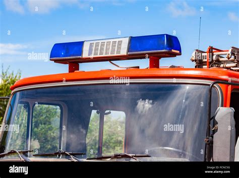 Close Up Of The Flashing Blue Siren Light On Roof Of Red Firetruck