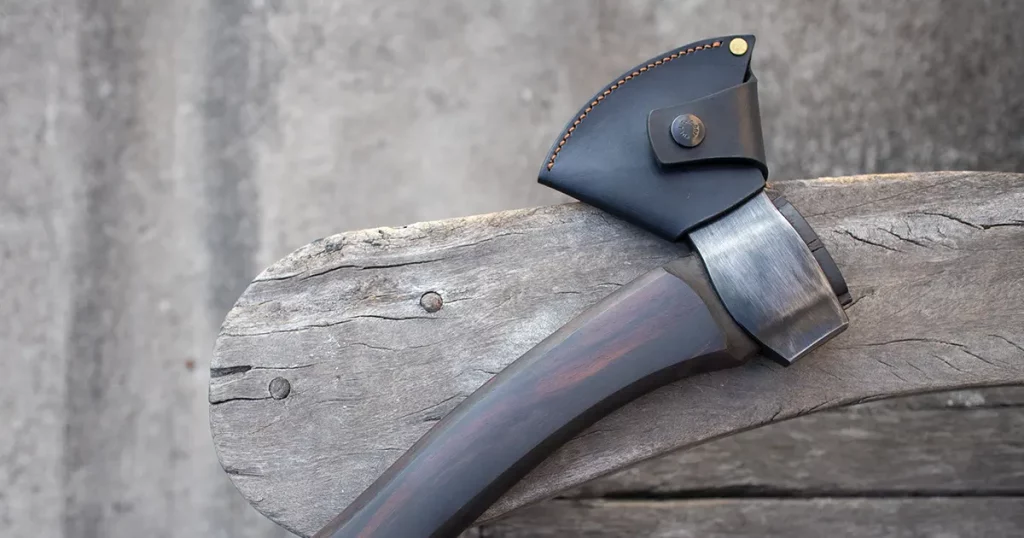 Carving axe with black leather sheath on table