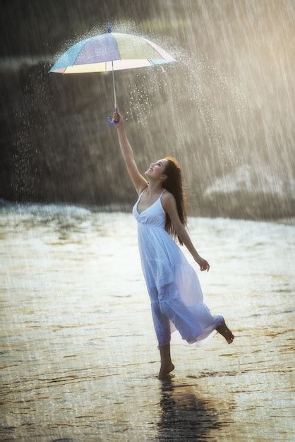 Premium Photo | Pretty young woman with rainbow umbrella, under summer rain