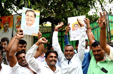 Supporters of Congress leader Siddaramaiah cheer while demanding chief minister post for him