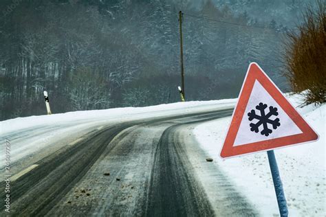 Snowy curvy road with traffic sign Stock Photo | Adobe Stock