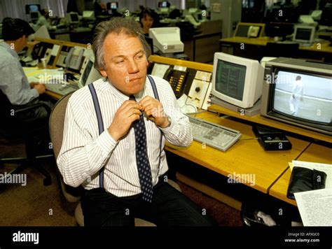 Peter Sissons portrait British television news presenter fixing tie in news room. 1980S HOMER ...