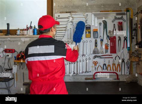 Picture of a mechanic cleaning tools in his workshop with a duster. Maintenance work and tool ...