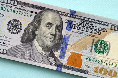 US Dollar Bills of a New Design with a Blue Stripe in the Middle is Lies on a Light Blue ...