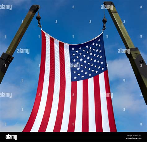 American flag hanging from military crane Stock Photo - Alamy