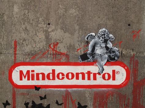 a wall covered in graffiti and stickers with the word mind control on it