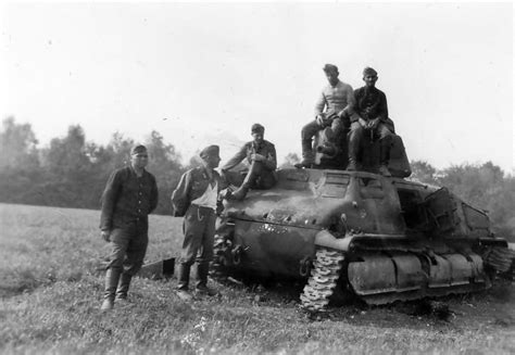 German troops pose next to a captured and damaged Somua S35 | World War Photos