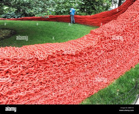 worker doing maintenance work on sinuous woven rope art Installation Red Yellow Blue by Orly ...