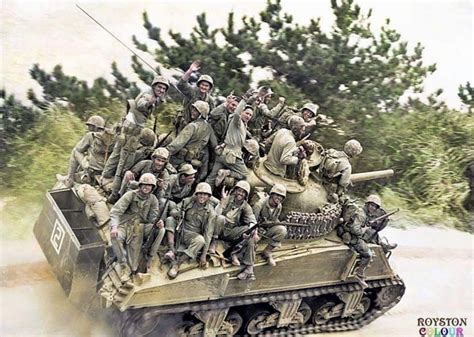 Troops of the 29th US Marine Regiment, 6th Marine Division, hitch a ride on a M4A3 Sherman 105mm ...