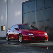 Red Mazda 323F with custom wheels