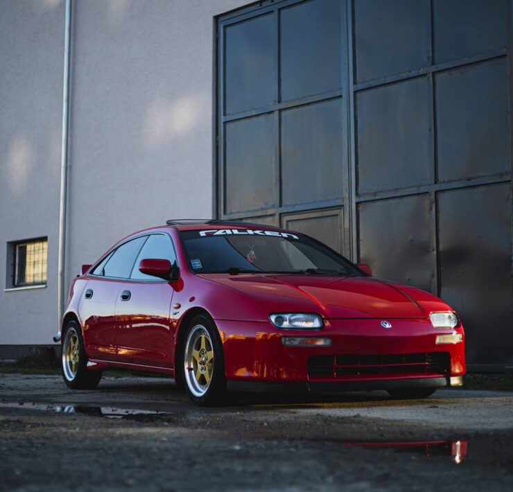 Red Mazda 323F with custom wheels