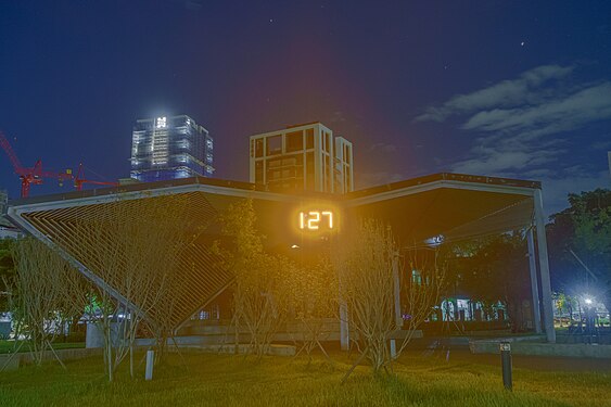 Outdoor elevated roof shelter in Banqiao Music park at night. It includes a digital clock