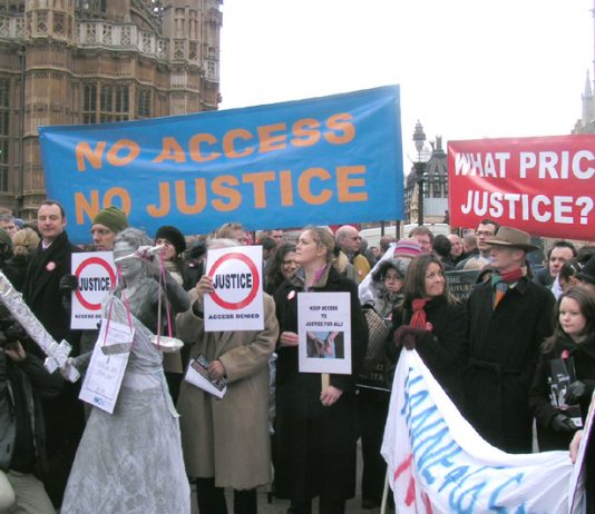 ‘Justice with her sword’ stands blindfolded among a crowd of hundreds of legal aid lawyers outside parliament on Monday