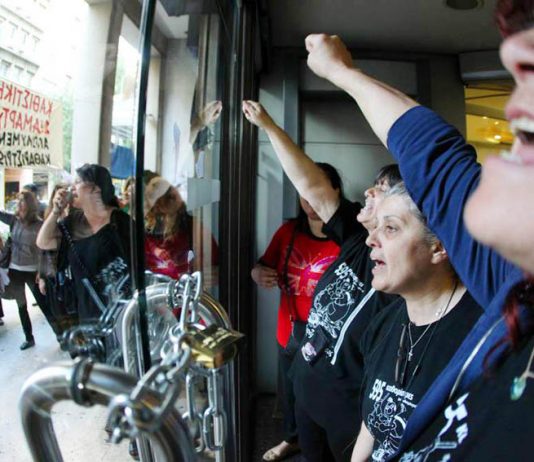 Sacked cleaners occupying the Greek Finance Ministry barricaded themselves in and chained the doors to keep the riot police out. Photo credit: MARIAS LOLOS