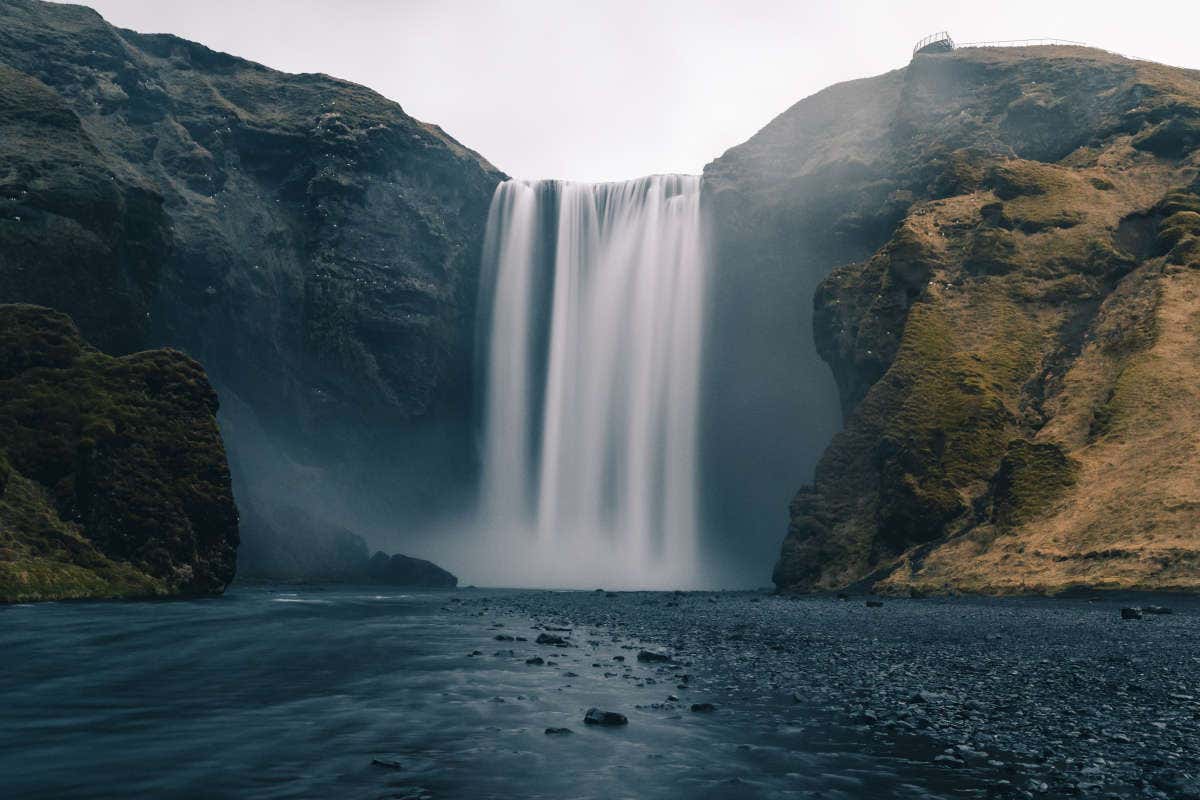 Contraste de la arena negra con el salto de agua