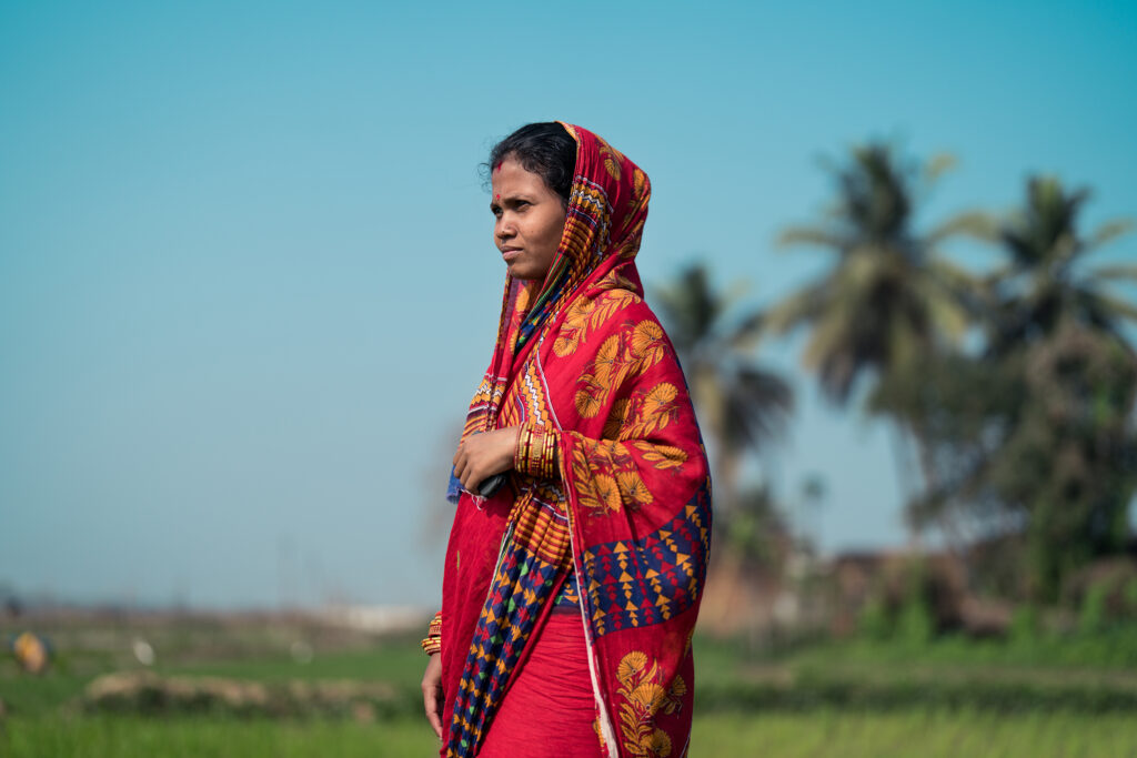 Manashi Pradhan (mother; 26 years old) at her rice farm in Tarakai, Khordha, State of Odisha, India.