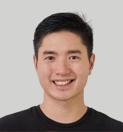 Headshot of man in black shirt with grey background