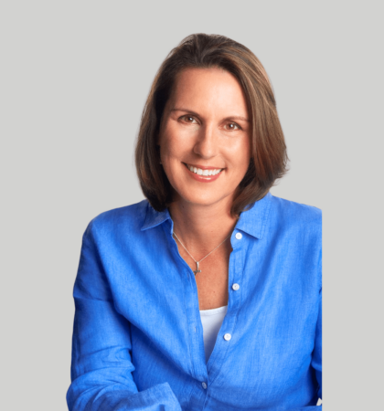 headshot of woman in blue shirt on gray background