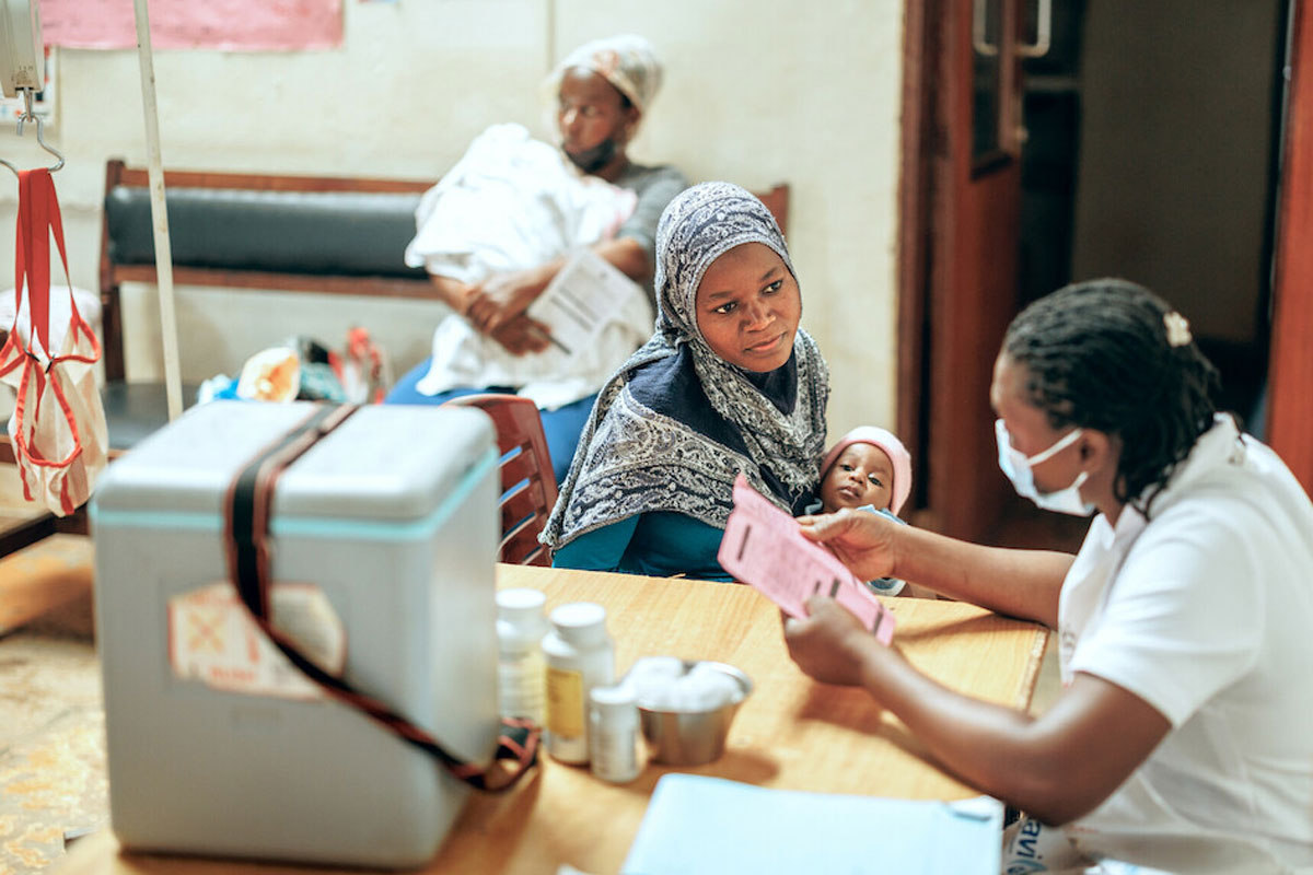 A mother with her baby talking to a nurse at a health clinic in Kampala, Uganda. Credit: Gavi/2024/Jjumba Martin