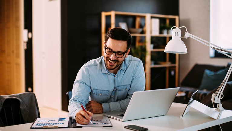 Young professional sitting at a desk and working happily 