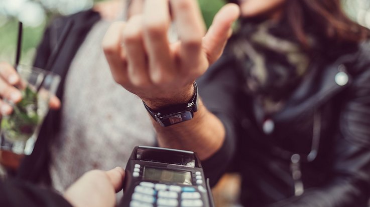 A woman pays contactless with her smartwatch