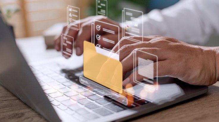 Hands typing on a laptop overlaid with digital folder icons