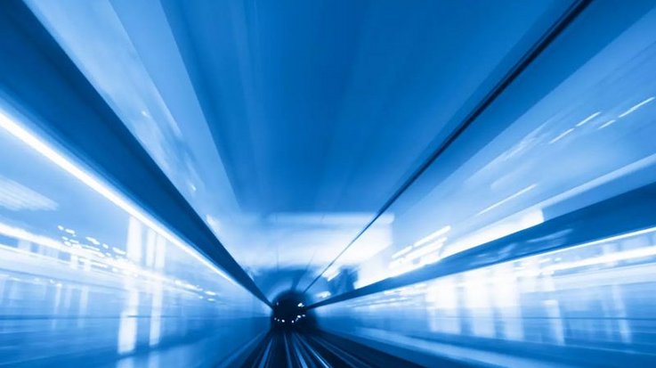 View into tunnel with tracks illuminated with blue light