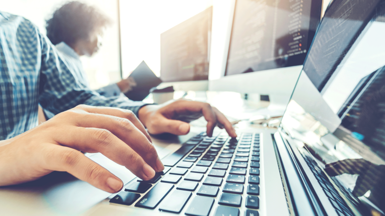 Close up of a person typing on a keyboard of a notebook