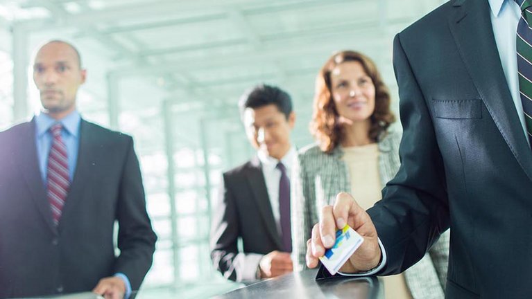 A businessman holds a card in his hand to gain access