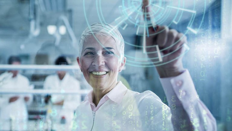 A woman dressed in white in a laboratory presses her finger on a computer-simulated display