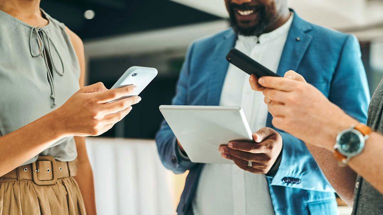 Group of people holding various mobile devices in their hands