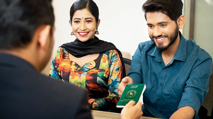 A man hands a passport to a couple