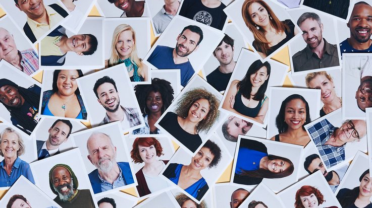 Mixture of multi-ethnic printed portraits scattered over a yellow background