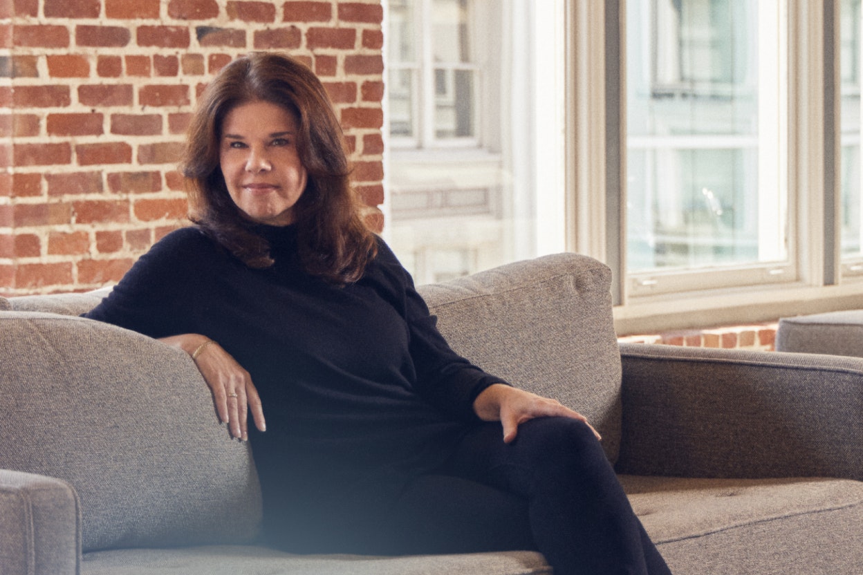 Portrait of Carolynn Levy seated on a couch.